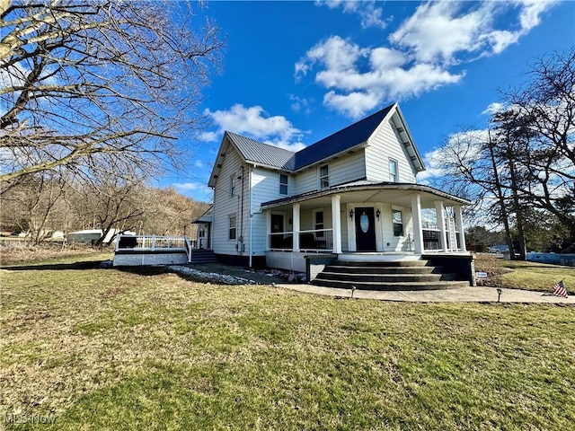 view of front of house with metal roof, a front lawn, and a porch