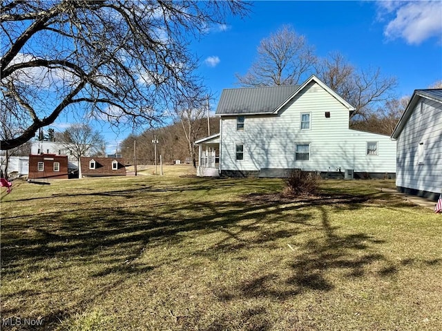 view of side of property featuring a yard and metal roof