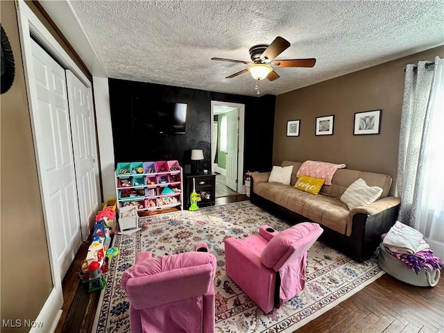 living area featuring ceiling fan, a textured ceiling, and parquet flooring