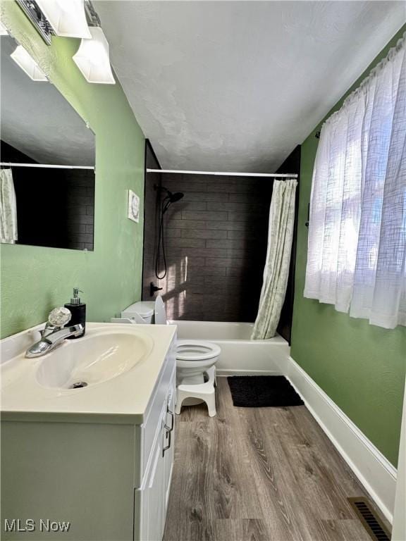 full bathroom featuring visible vents, toilet, vanity, wood finished floors, and baseboards