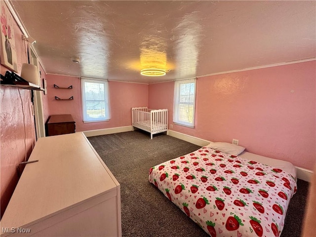 bedroom with a textured ceiling, a textured wall, dark carpet, and baseboards