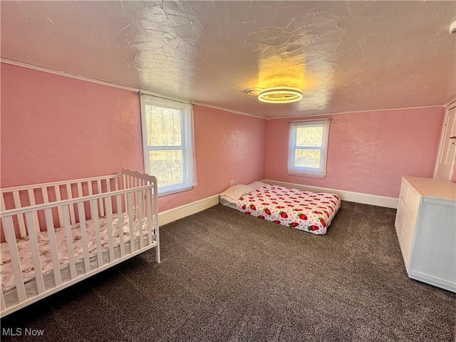 carpeted bedroom featuring a textured ceiling, a textured wall, and baseboards