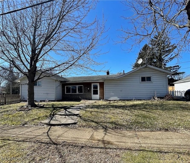 ranch-style house with fence and a front lawn