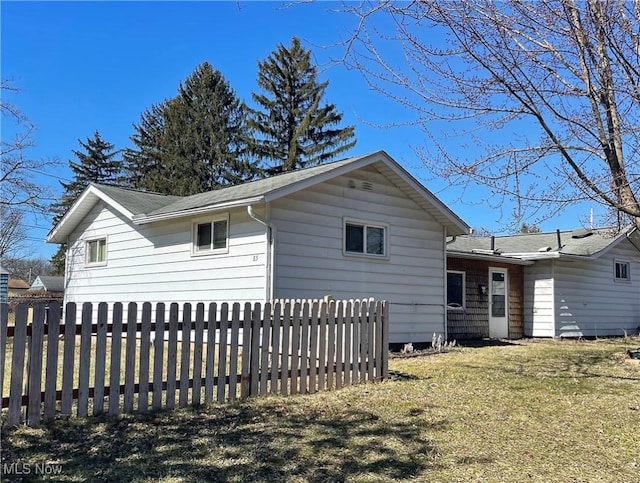 view of side of home featuring a fenced front yard and a yard