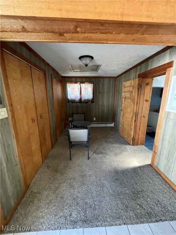 interior space featuring wooden walls, visible vents, crown molding, carpet floors, and beam ceiling