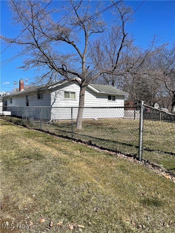 view of side of home with fence private yard and a yard