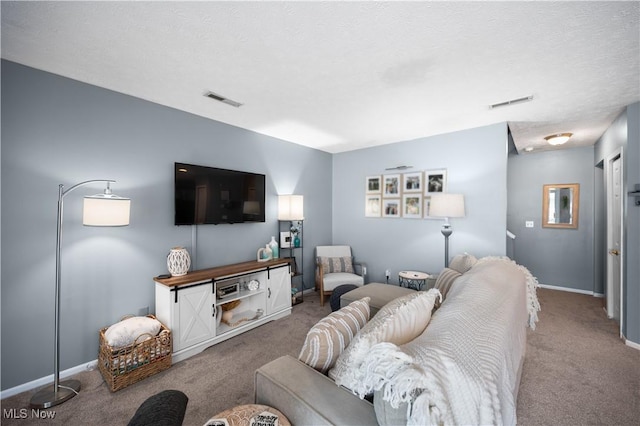 carpeted living area with visible vents, a textured ceiling, and baseboards