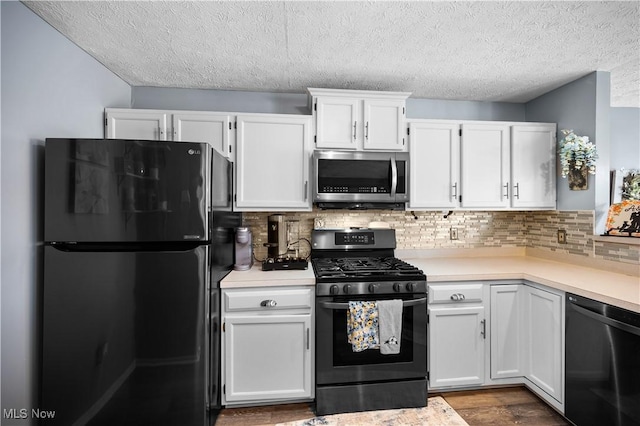 kitchen with range with gas stovetop, dishwashing machine, freestanding refrigerator, light countertops, and stainless steel microwave