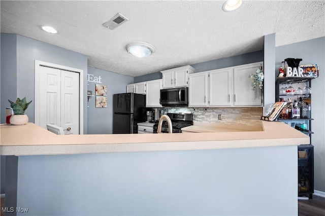 kitchen featuring a peninsula, light countertops, visible vents, and stainless steel appliances