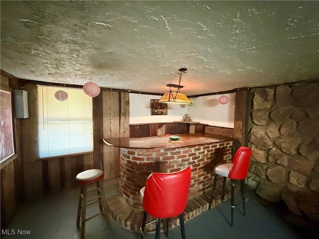 bar with a textured ceiling and a bar