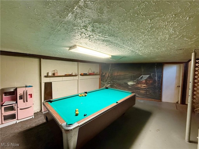 recreation room featuring concrete block wall, a textured ceiling, and pool table