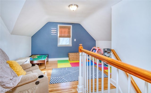 rec room with lofted ceiling, baseboards, and wood finished floors