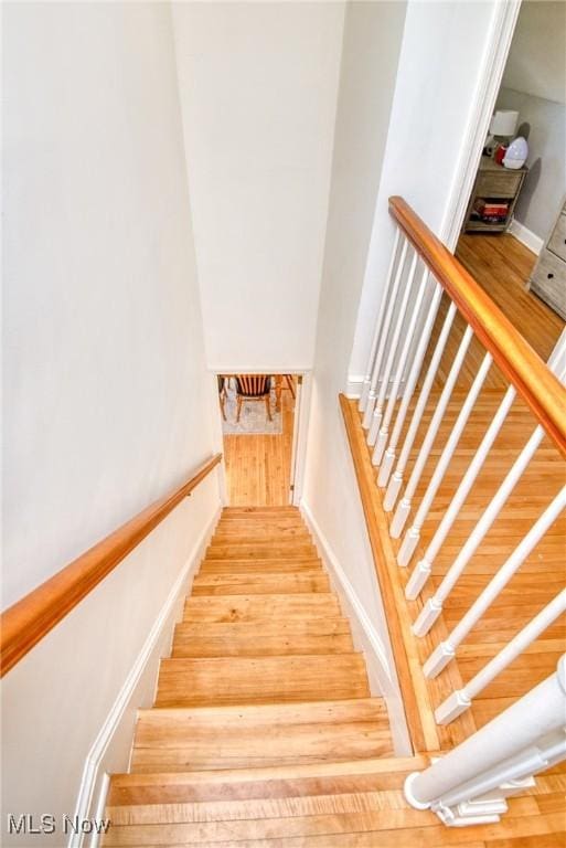 stairs with wood finished floors and baseboards