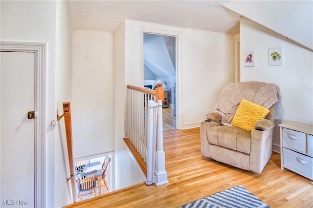 living area with an upstairs landing and wood finished floors