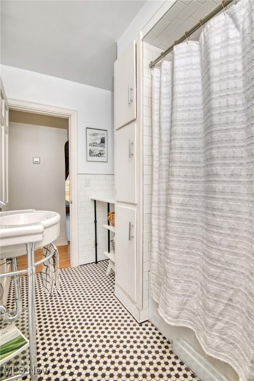 full bath with shower / bath combination with curtain and tile patterned floors