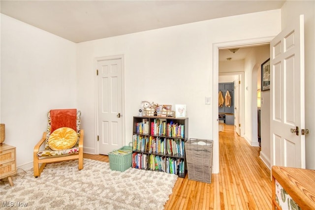 living area with hardwood / wood-style flooring and baseboards