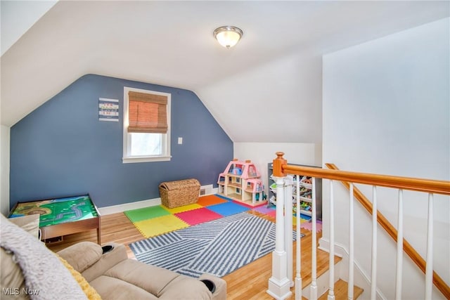 playroom featuring vaulted ceiling, wood finished floors, and baseboards