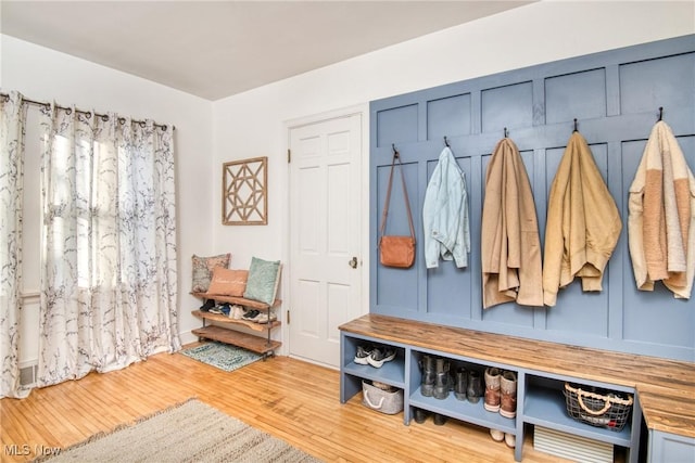 mudroom featuring a decorative wall and wood finished floors