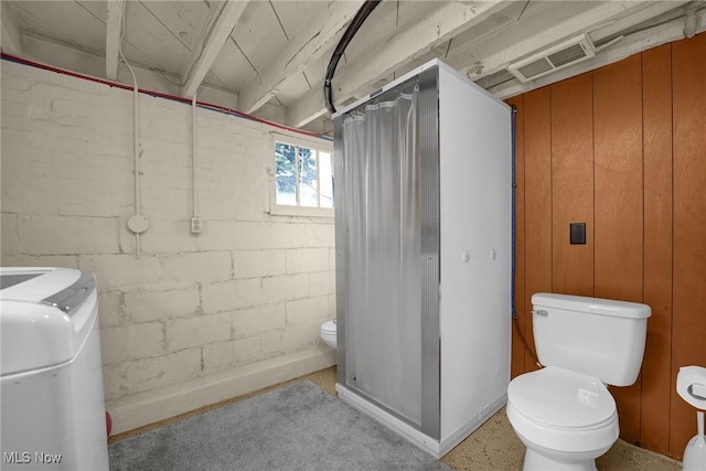 bathroom featuring toilet, visible vents, and concrete block wall