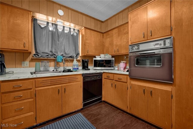 kitchen with black dishwasher, stainless steel microwave, oven, light countertops, and a sink