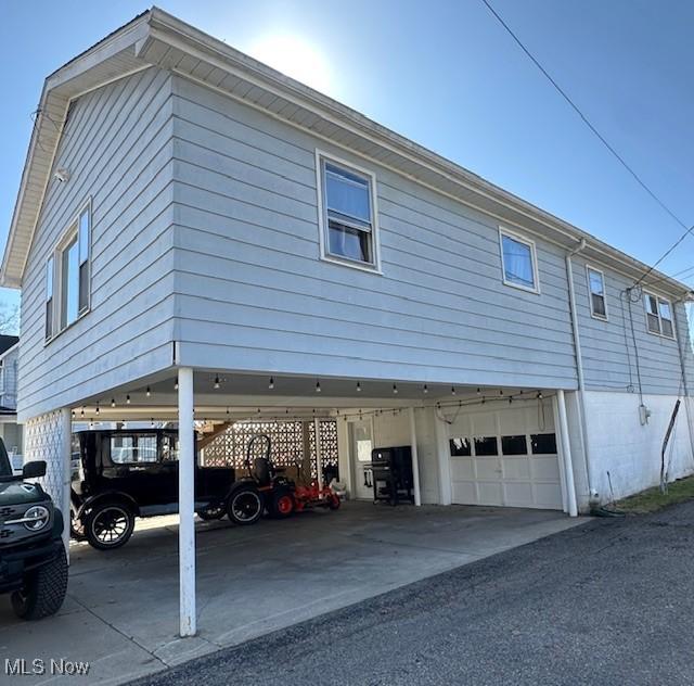 view of home's exterior featuring an attached garage and a carport