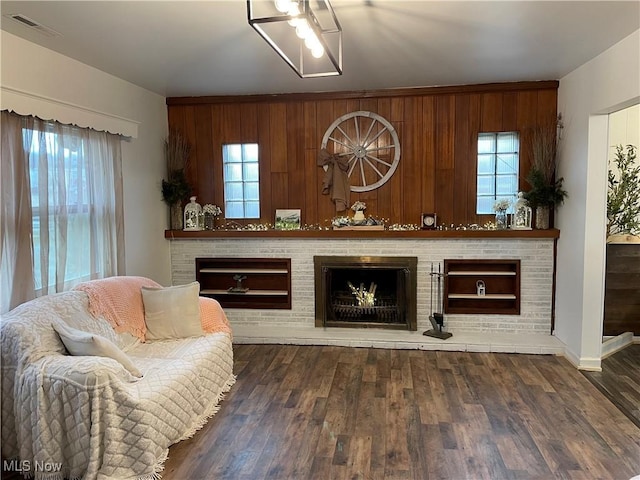 living room featuring visible vents, a fireplace, wood finished floors, and a wealth of natural light