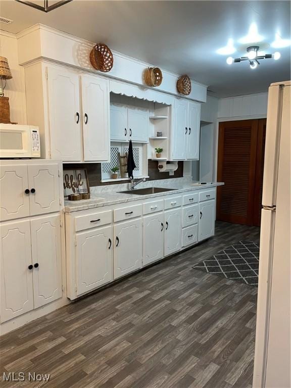 kitchen with dark wood-style flooring, open shelves, white cabinets, a sink, and white appliances