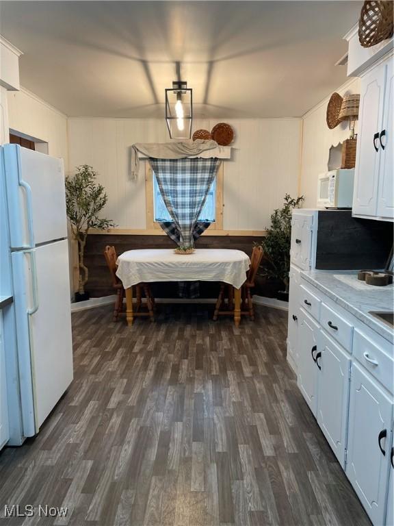 kitchen with light countertops, white appliances, dark wood finished floors, and white cabinets