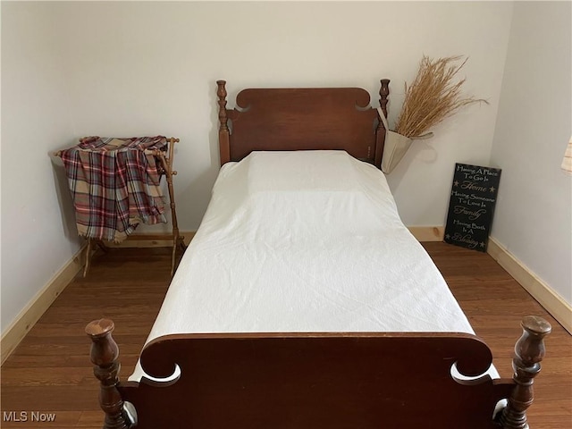 bedroom featuring wood finished floors and baseboards