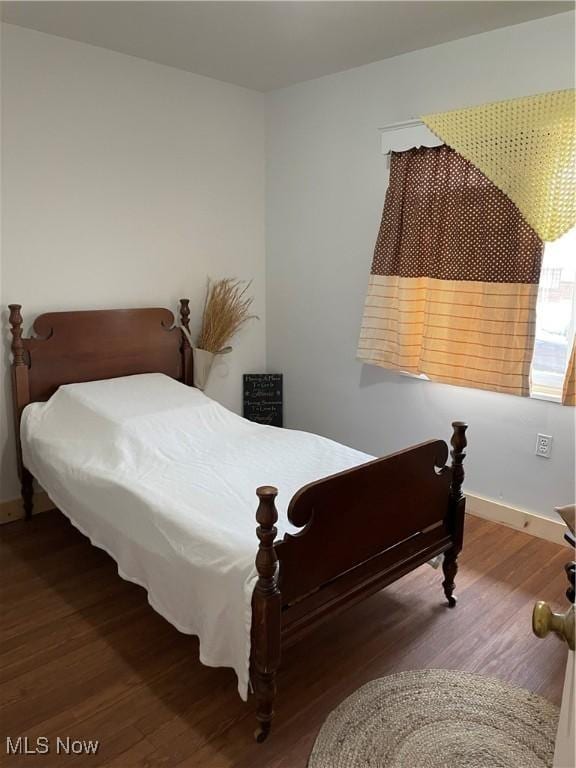 bedroom with baseboards and wood finished floors