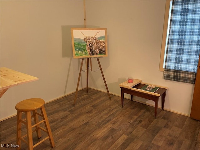 dining space featuring dark wood-style flooring and baseboards