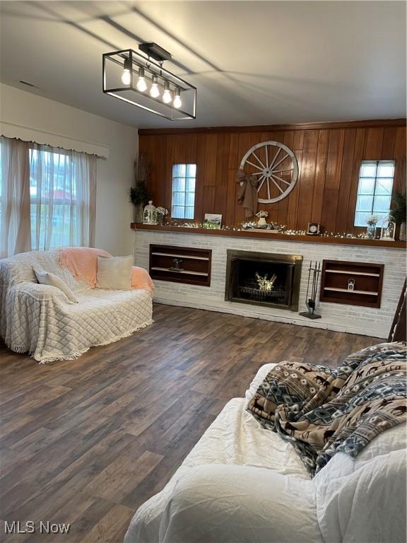 living area featuring a brick fireplace and wood finished floors