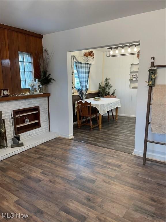 living room with a brick fireplace, wood finished floors, and baseboards