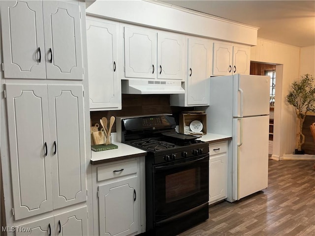 kitchen with under cabinet range hood, dark wood-style flooring, white cabinetry, freestanding refrigerator, and gas stove