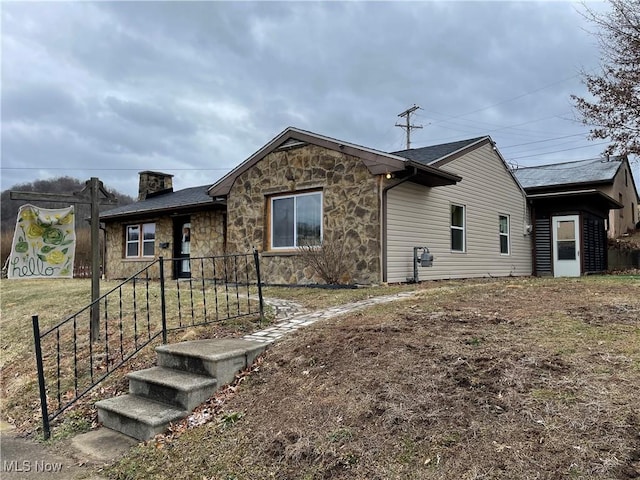 exterior space with stone siding and fence