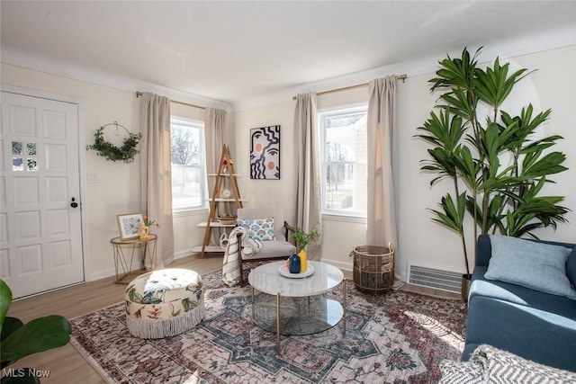 sitting room featuring visible vents, baseboards, and wood finished floors