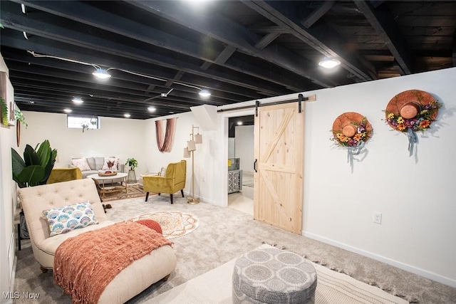 below grade area featuring carpet, baseboards, and a barn door