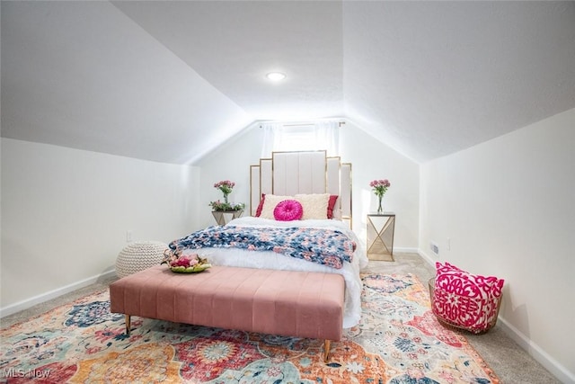 bedroom featuring lofted ceiling, baseboards, and carpet flooring