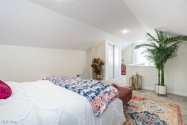 bedroom featuring vaulted ceiling, carpet flooring, visible vents, and baseboards