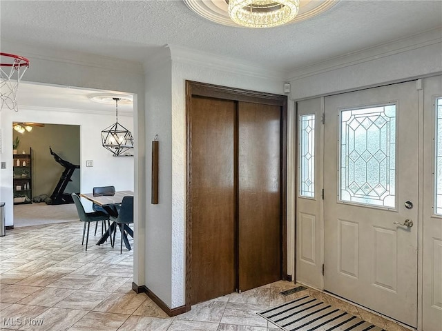 entrance foyer featuring crown molding, a textured ceiling, and baseboards