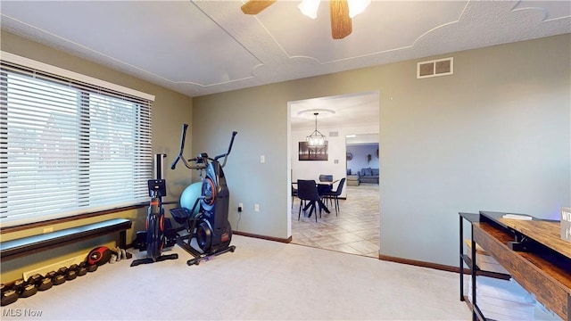 workout area featuring carpet floors, a ceiling fan, visible vents, and baseboards