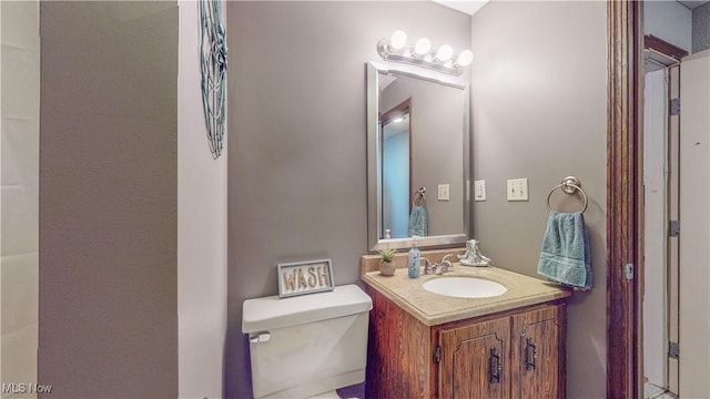 bathroom featuring toilet and vanity