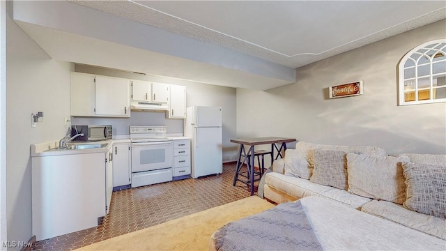 kitchen featuring white appliances, open floor plan, light countertops, under cabinet range hood, and a sink