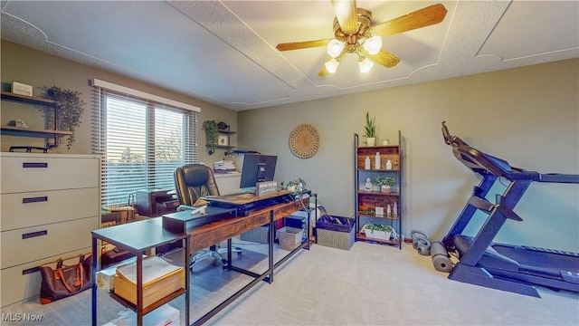 carpeted home office featuring ceiling fan