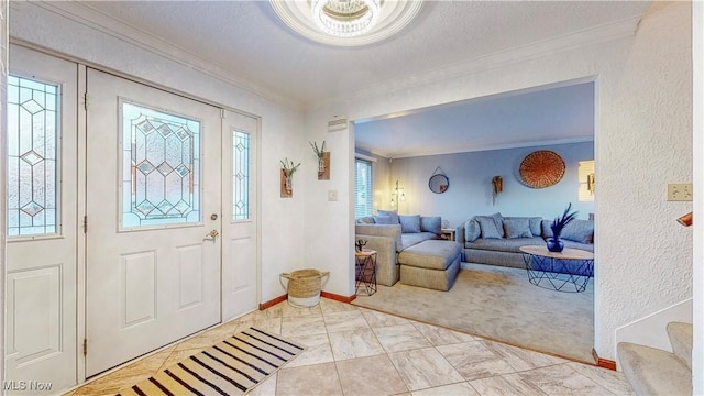 foyer entrance with a textured ceiling, baseboards, and crown molding