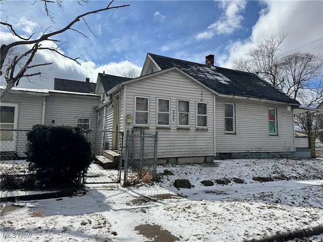 exterior space with a gate, fence, and a chimney