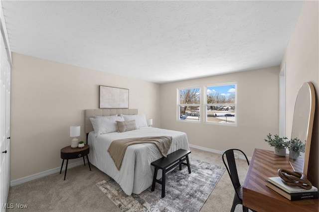 bedroom featuring a textured ceiling, baseboards, and carpet flooring