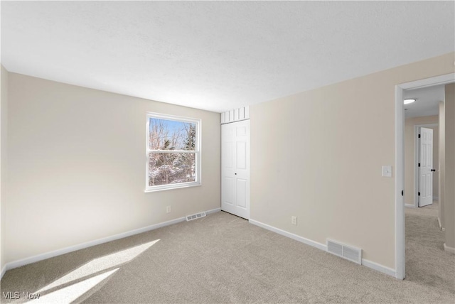 carpeted empty room with baseboards and visible vents