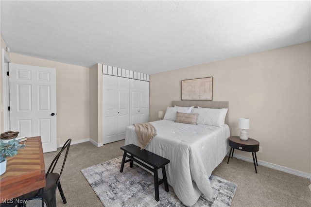 carpeted bedroom with a closet and baseboards