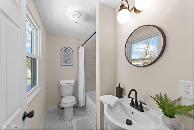 bathroom with toilet, baseboards, a sink, and shower / tub combo with curtain